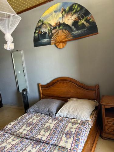 a bedroom with a bed with a painting on the wall at Chez Lolah in Diego Suarez
