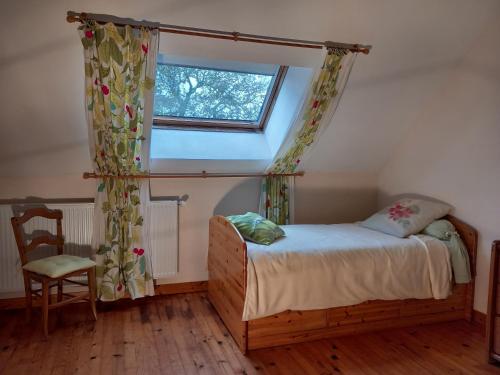 a bedroom with a bed and a window and a chair at Etape à Villeperdue in La Barillonnerie