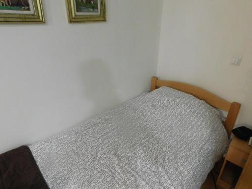 サラエボにあるApartment Sabinaの白い壁のベッドルームのベッド1台