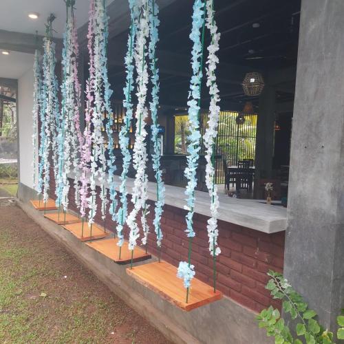 a string of blue and white flowers hanging from a building at moments hotel & restaurant in Hikkaduwa