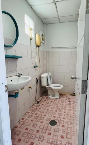 a bathroom with a toilet and a sink at Montra Guesthouse in Ranong