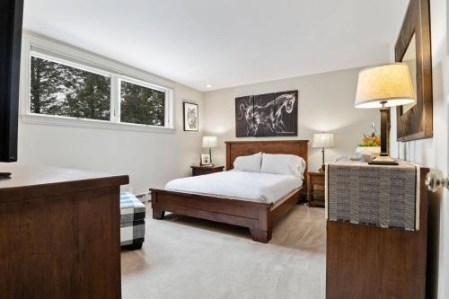 a bedroom with a bed and two windows at RMR: Teodori House in Teton Village in Teton Village