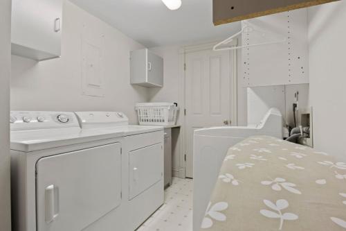 a white kitchen with a sink and a dishwasher at RMR: Teodori House in Teton Village in Teton Village