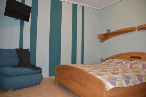 1 dormitorio con 1 cama y 1 silla azul en Ferienwohnung Familie Stuhr en Staatz