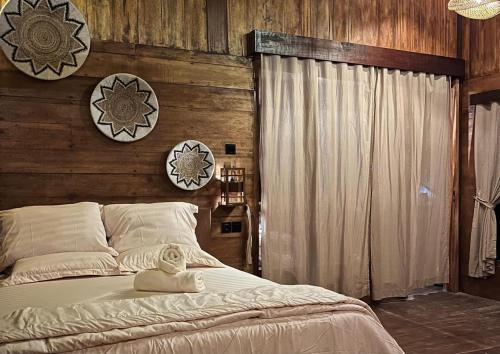 a bedroom with a bed with two clocks on the wall at Living On Air in Pulau Sarang