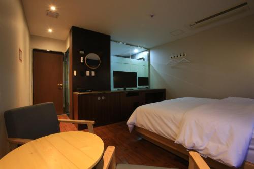 a bedroom with a bed and a table and a television at The Ace Hotel in Seoul
