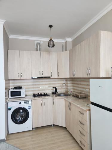 Una cocina con lavadora y secadora. en Your Comfort, en Kutaisi