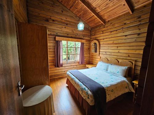 グラスコップにあるLisbon Eco Lodgeの木造キャビン内のベッド1台が備わるベッドルーム1室を利用します。