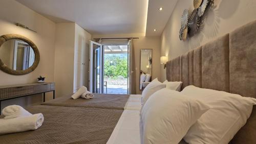 a bedroom with two beds and a mirror at Villa Bacchus Kassiopi Corfu in Kassiopi