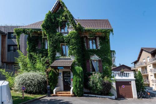 a house covered in ivy on a street at Zenitude Evian Les Terrasses du Lac, an Ascend Collection Hotel in Évian-les-Bains