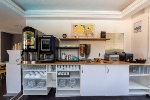 エヴィアン・レ・バンにあるZenitude Evian Les Terrasses du Lac, an Ascend Collection Hotelの白いキャビネットとカウンター付きのキッチン