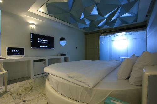 a bedroom with a white bed with a blue ceiling at The Ace Hotel in Seoul