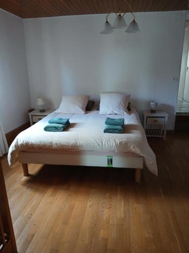 a bedroom with a bed with two green towels on it at Les Jardins des 3 Provinces- Gîte in Montcharvot