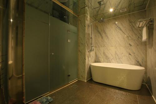 a bathroom with a shower and a bath tub at The Ace Hotel in Seoul