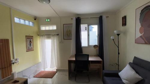 a living room with a desk and a couch at Le Studio Marin in Bouéni