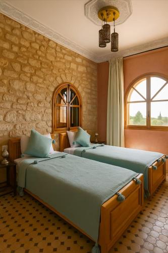 a bedroom with two beds and a window at Villa Douira avec piscine, proche d'Essaouira in Essaouira