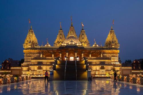 un gran edificio con gente parada frente a él en Home away from Home close to Swaminarayan Temple, en Nadiād