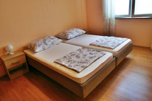 two twin beds in a room with wooden floors at Apartment Gare in Kastav