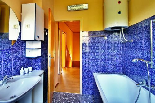 uma casa de banho com uma banheira, um lavatório e um WC. em Apartment Gare em Kastav