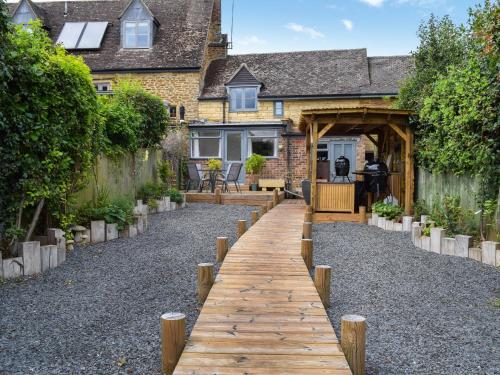 a wooden walkway in front of a house at Juniper Cottage in Hook Norton