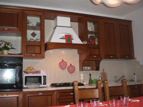 uma cozinha com armários de madeira e um forno com placa de fogão em La Casa nella Vecchia Ferrovia em Arsiero