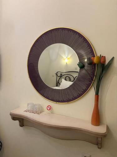 a mirror on a wall above a shelf with a vase at Le Bijou Luxury Rooms & Suites in Veria