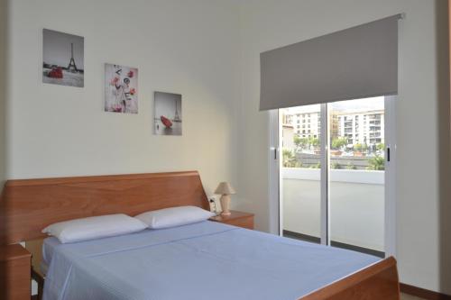 1 dormitorio con 1 cama grande y ventana en Urban Flat, en Santa Cruz de Tenerife