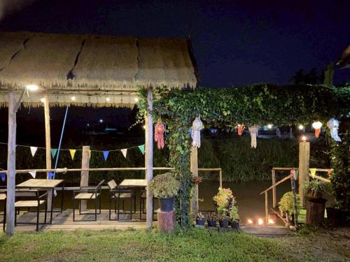 a gazebo with a table and chairs at night at Banna Cafe & Glamping บ้านนา คาเฟ่ แอนด์ แกรมปิ้ง in Fang