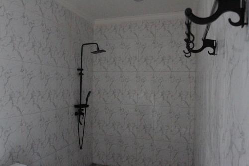 eine Dusche mit einem an der Wand hängenden Regenschirm in der Unterkunft Ayuna Cottages in Bedahulu