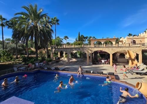 a group of people playing in a swimming pool at Castell Villa Bohío Mallorca in Urbanicacion ses palmeres