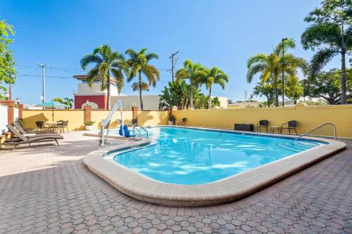 a swimming pool in a patio with palm trees at Quality Inn Tampa Airport - Cruise Port in Tampa