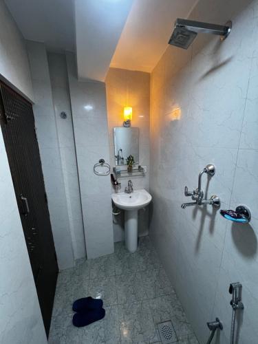 une salle de bains avec un lavabo blanc et un miroir dans l'établissement Bista Niwas, à Bhaktapur