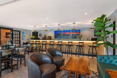 a restaurant with a bar with leather chairs and tables at Maine Evergreen Hotel, an Ascend Collection Hotel in Augusta