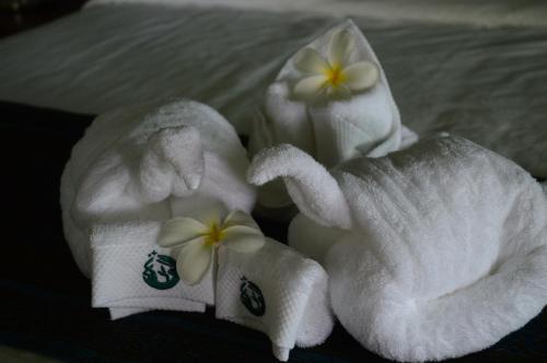 zwei Handtücher mit Blumen auf dem Bett in der Unterkunft The Moon Rabbit Resort Pai in Pai