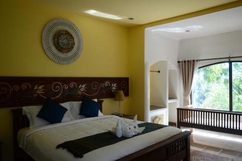 ein Schlafzimmer mit einem Bett und einem großen Fenster in der Unterkunft The Moon Rabbit Resort Pai in Pai