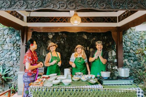 a group of women standing around a table with food at Dewangga Suite in Ubud
