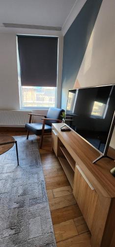 a living room with a large flat screen tv at Home on Piccadilly Line in London