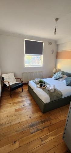a bedroom with a large bed and a window at Home on Piccadilly Line in London