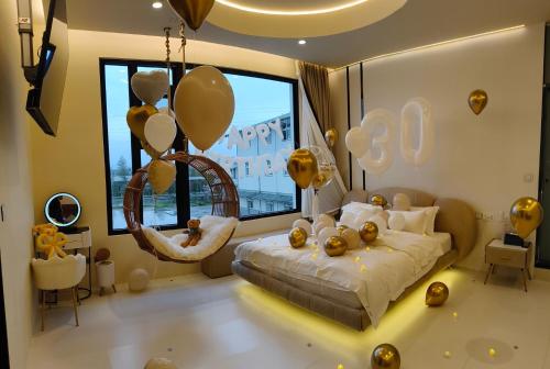 een slaapkamer met ballonnen en een bed met een schommel bij 7star in Guilin