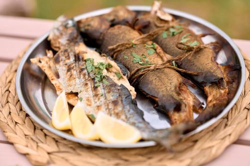 un plato de comida con pescado y rodajas de limón en stream housee, en Slavske