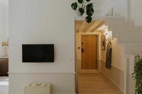 a hallway with a flat screen tv on a wall at Lwowska Studios - STAYINWARSAW in Warsaw