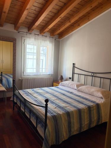 a bedroom with a bed with a striped blanket at Apartments Orio in Orio al Serio