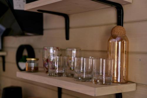 una fila de vasos sentados en un estante en stream housee, en Slavske