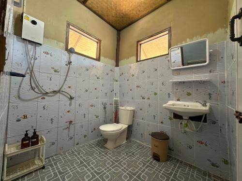 a bathroom with a toilet and a sink and a tv at FourTwoEight Pai Resort in Kampong Huaibū