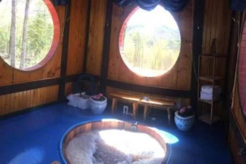 une baignoire dans une pièce avec deux fenêtres dans l'établissement Cozy Tented Cabin Rental near the Hudson River in Upstate New York, à North River