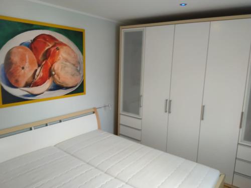 een slaapkamer met een bed en een schilderij van fruit bij Appartement Rdc in Wawern