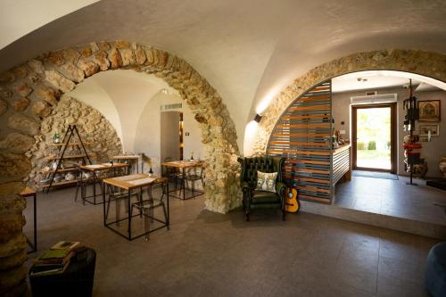 une pièce avec un mur en pierre et quelques tables et chaises dans l'établissement 18Th Century Farmhouse In Racalmuto Countryside, à Grotte
