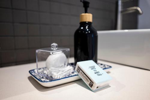 un bancone del bagno con una bottiglia di sapone e una saponetta di Stylish OceanBreeze 50 Central Mossel Bay a Mossel Bay