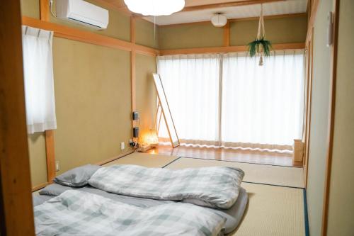 two beds in a room with a window at ヴィラこんぴら Villa Konpira in Kotohira