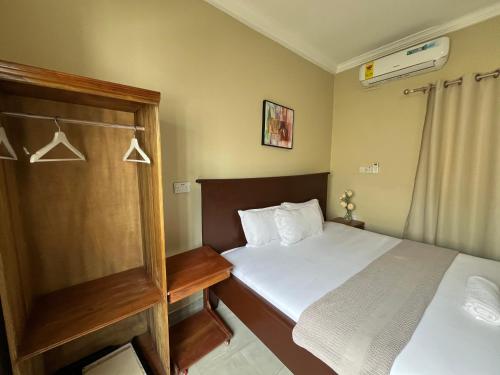 a small bedroom with a bed and a shower at Mar Luther Inn in Aburi